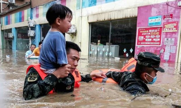 拯救人員正在水災中抬起一名兒童