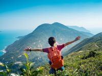 person standing on the hill with open arms